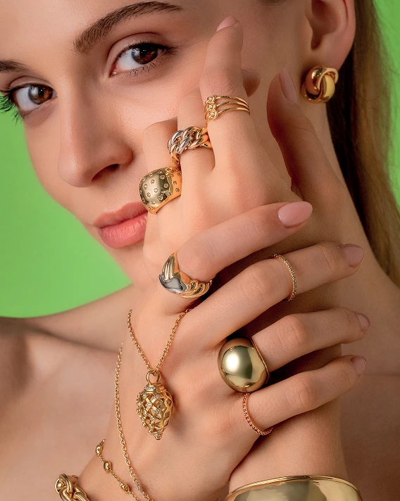 foto di una donna in primo piano con anelli bracciali e orecchini